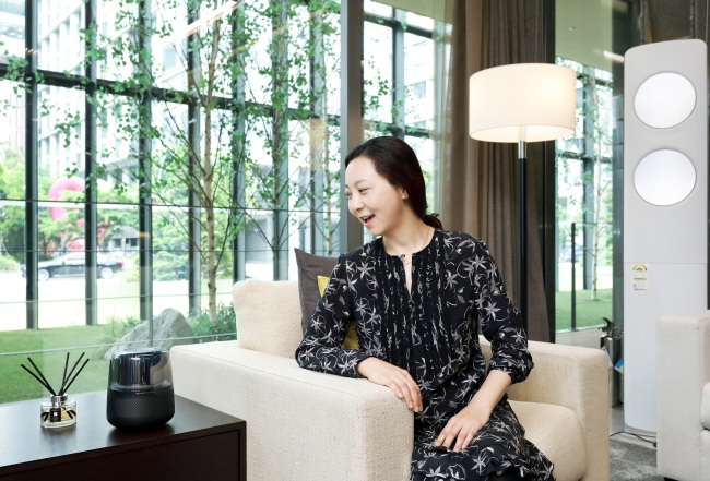 A model speaks to an AI speaker at Samsung C&T’s Raemian IoT HomeLab. (Samsung C&T)