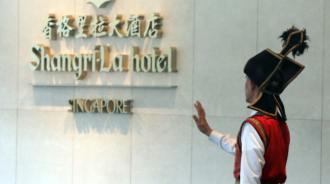 A hotel employee hails a cab at the Shangri-La Hotel in Singapore. (Yonhap)
