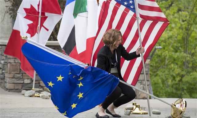 <YONHAP PHOTO-2913> A staffer tries to secure the flags blowing in the wind during a meeting for the G7 Finance and Central Bank Governors in Whistler, British Columbia, Thursday, May 31, 2018. (Jonathan Hayward/The Canadian Press via AP)/2018-06-01 05:51:34/ <저작권자 ⓒ 1980-2018 ㈜연합뉴스. 무단 전재 재배포 금지.>