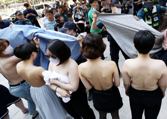 Activists from feminist group Fire Femi Action protest topless against Facebook’s sexually discriminatory policy, in front of Facebook Korea in Gangnam, Seoul, Saturday. (Yonhap)
