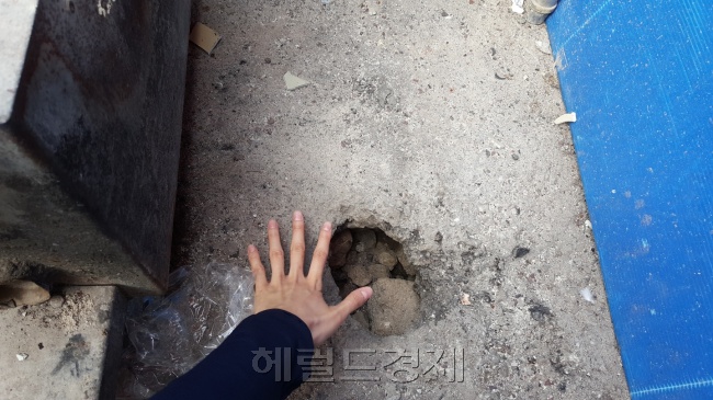 사고현장 인근에 움푹 패인 도로. 사람 손바닥 만한 크기의 구멍이 뚫렸다. [사진=정세희 기자/say@heraldcorp.com]