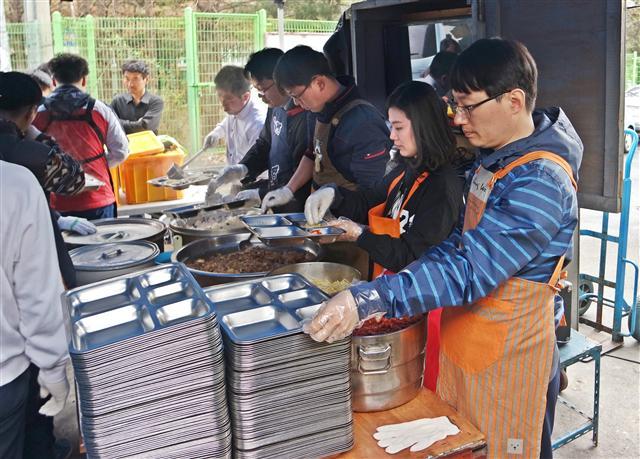 유진투자증권 직원들이 사회봉사활동의 일환으로 지역복지시설에서 식사 보조, 무료 배식 활동에 참여하고 있다.
