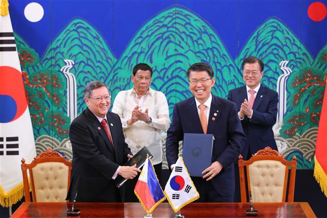 문재인 대통령과 로드리고 두테르테 필리핀 대통령이 4일 오후 청와대에서 열린 한·필리핀 ‘세부신항만건설사업’ 차관공여 계약 체결 서명식에서 은성수 수출입은행장과 도밍게즈 필리핀 재무부 장관의 계약서 서명을 지켜보고 있다.  [연합뉴스]