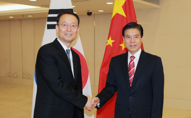 Paik Un-gyu, South Korean minister of trade, industry and energy (L), shakes hands with China's Commerce Minister Zhong Shan (R) during their meeting in Beijing on June 5, 2018, in this photo provided by the Korean ministry. (Yonhap)