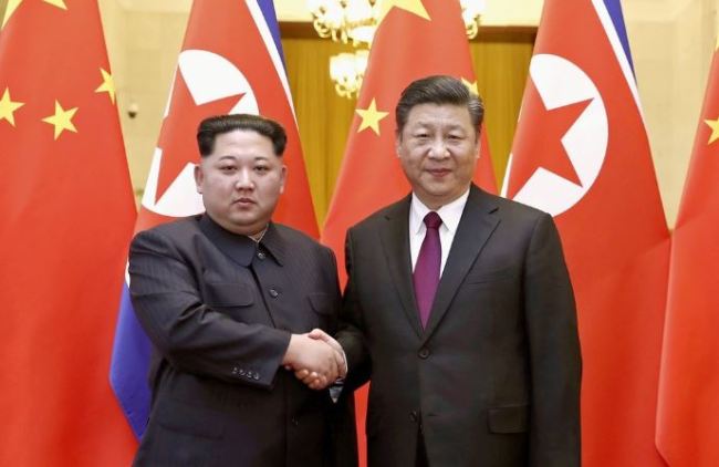 North Korean leader Kim Jong-un, left, shakes hands with Chinese President Xi Jinping. (AP-Yonhap)