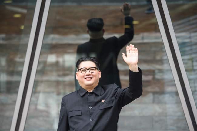 Kim Jong-un impersonator, who goes by the name Howard X, waves outside a building while dressed up as the North Korean leader in Hong Kong on June 7, 2018. (AFP-Yonhap)