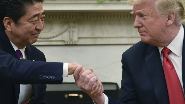 US President Donald Trump (R) and Japanese Prime Minister Shinzo Abe shaking hands during a meeting at the White House in Washington on June 7, 2018. (Yonhap)