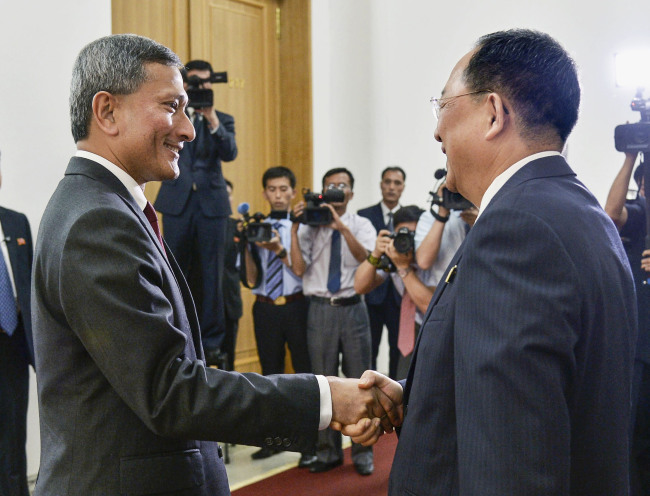 Singaporean Foreign Minister Vivian Balakrishnan, left, shakes hands with his North Korean counterpart Ri Yong-ho. (Yonhap)