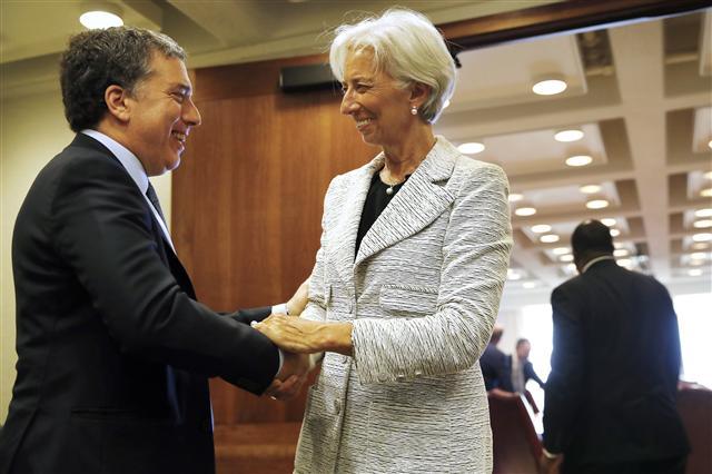 니콜라스 두호브네 아르헨티나 재무부 장관이 지난 5월 워싱턴의 국제통화기금(IMF) 본부에서 크리스틴 라가르드 IMF 총재와 악수하고 있다.  [AP연합뉴스]