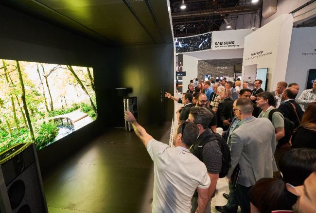 Visitors photograph Samsung Electronics’ newest Micro LED display The Wall, designed in collaboration with Denmark’s Steinway Lyngdorf audio system at the InfoComm 2018 held in Las Vegas on Friday. The two companies announced a partnership to provide enhanced audiovisual experiences for the next-generation micro LED display. (Samsung Electronics)