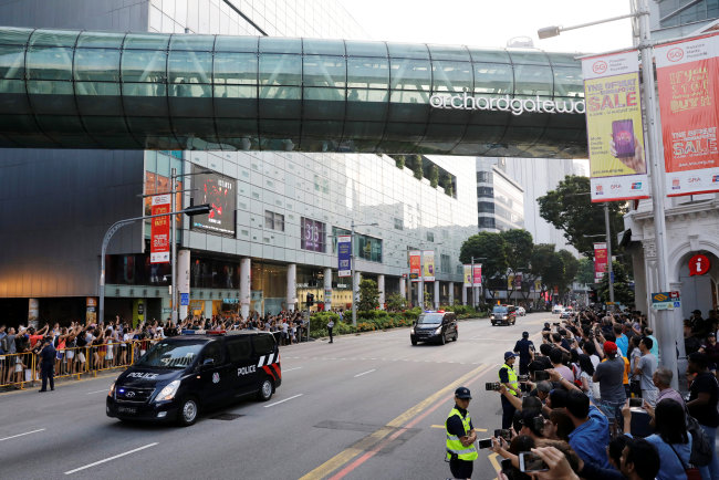 Police vehicles escort as the motorcade of North Korean leader Kim Jong-un makes its way to the Istana. (Reuters-Yonhap)