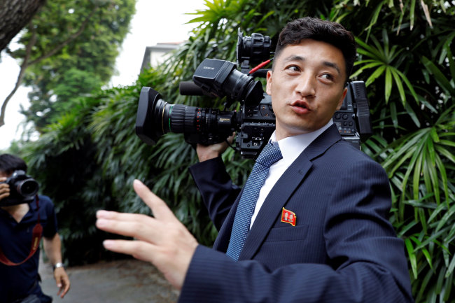 A North Korean cameraman reacts as he is chased by media outside St Regis hotel. (Reuters-Yonhap)