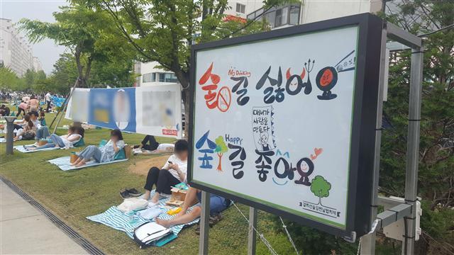 서울 마포구 연남동 경의선숲길에서 시민이 돗자리를 편 채 휴식을 즐기고 있다. 돗자리마다 맥주가 담긴 일회용컵이 눈에 띈다. ‘음주청정지역’을 안내하는 표지판이 무색하다.
이원율 기자/yul@heraldcorp.com