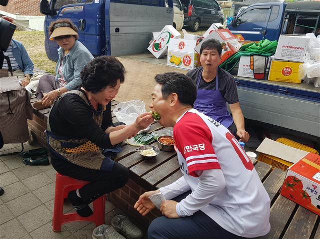 자유한국당 소속 남경필 경기도지사 후보가 8일 남양주 마석우리장에서 만난 상인에게서 쌈밥을 얻어먹고 있다.