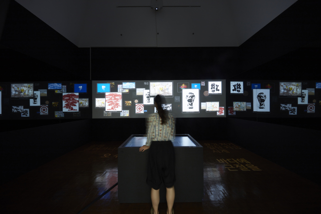 일상의 실천, poster generator 1962-2018, 인터렉티브 미디어 설치, 터치스크린, 프로젝터, PC, 사운드, 600x440cm(가변크기), 2018 [사진제공=서울시립미술관]