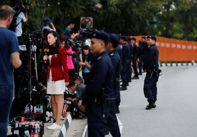 Members of the media work as security personnel keep watch near the entrance to the Capella Hotel in Singapore on Tuesday. (Yonhap)