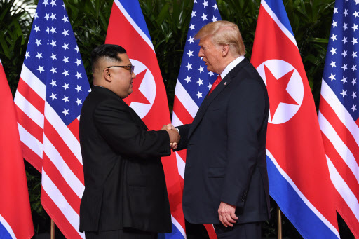 North Korea's leader Kim Jong Un (L) shakes hands with US President Donald Trump (R) at the start of their historic US-North Korea summit, at the Capella Hotel on Sentosa island in Singapore on June 12, 2018. (AFP)