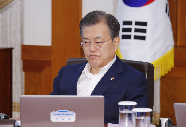 President Moon Jae-in watches a TV broadcast as Kim Jong-un and Donald Trump meet in Singapore, during Tuesday's Cabinet meeting. (Yonhap)