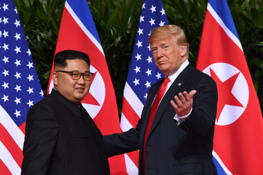 US President Donald Trump (right) gestures as he meets with North Korea's leader Kim Jong-un at the start of their historic US-North Korea summit, at the Capella Hotel on Sentosa island in Singapore on Tuesday. (AFP)