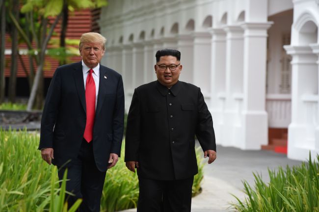 North Korea's leader Kim Jong-un (R) walks with US President Donald Trump (L) during a break in talks at their historic US-North Korea summit, at the Capella Hotel on Sentosa island in Singapore on Tuesday. (AFP)