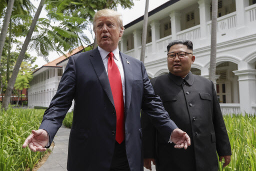 US President Donald Trump and North Korea leader Kim Jong-un stop to talk with the media as they walk from their lunch at the Capella resort on Sentosa Island on Tuesday in Singapore. (AP)
