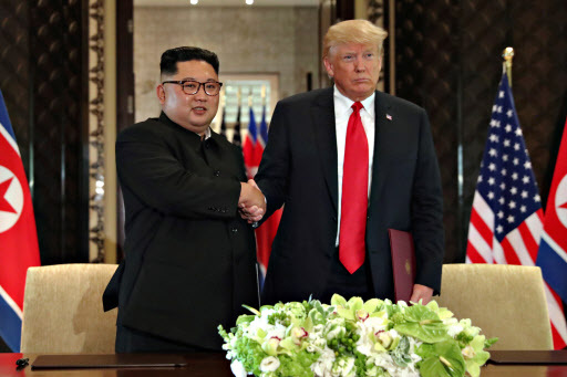 US President Donald Trump shakes hands with North Korea's leader Kim Jong-un after they signed documents that acknowledged the progress of the talks and pledge to keep momentum going, after their summit at the Capella Hotel on Sentosa island in Singapore June 12, 2018. / REUTERS