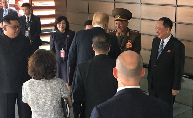 US President Donald Trump, center, shakes hands with North Korean People's Armed Forces Minister No Kwang-chol at the historic summit between the US and North Korea in Singapore on Tuesday. (Yonhap)