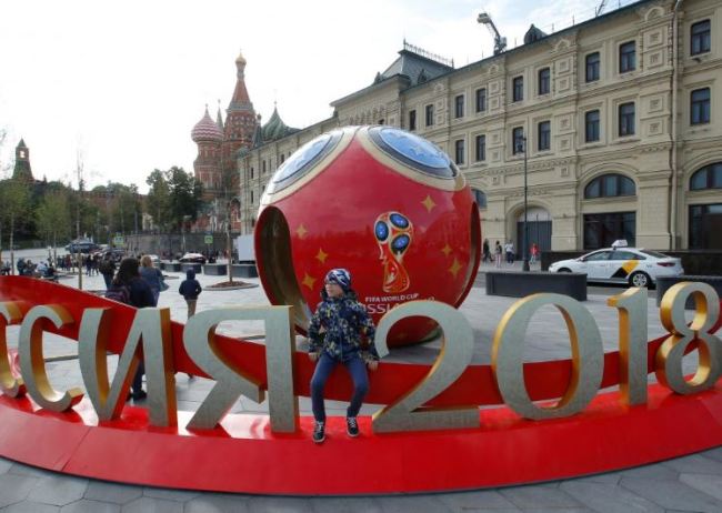 People gather near decorations for the upcoming 2018 FIFA World Cup, with St. Basil's Cathedral seen in the background, in central Moscow, Russia on June 7. (Reuters)