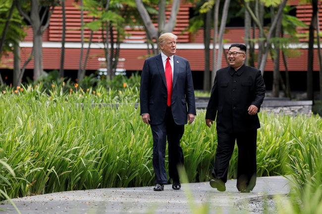 US President Donald Trump and North Korea's leader Kim Jong-un walk together before their working lunch during their summit at the Capella Hotel on the resort island of Sentosa, Singapore Tuesday. (Reuters)