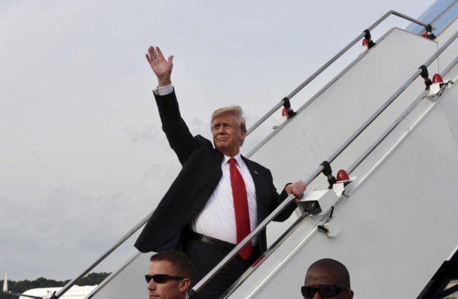 In this photo released by the Ministry of Communications and Information, Singapore, US President Donald Trump waves as he boards Air Force One following a summit with North Korean leader Kim Jong-un Tuesday in Singapore. (AP)