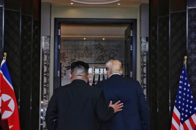 US President Donald Trump walks with North Korean leader Kim Jong-un at the Capella Hotel on Sentosa island in Singapore on Tuesday. EPA
