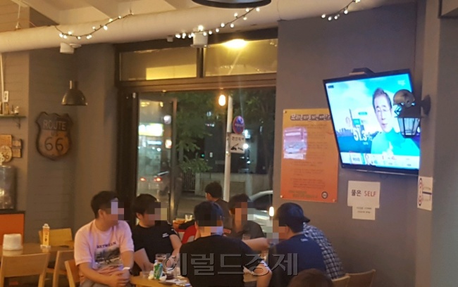 치킨 집에서 선거 결과를 지켜보고 있는 사람들(왼쪽 사진)과 지하철 대합실에서 선거 방송을 보고 있는 시민들.  정세희 기자/say@heraldcorp.com