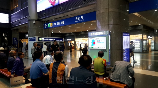 치킨 집에서 선거 결과를 지켜보고 있는 사람들(왼쪽 사진)과 지하철 대합실에서 선거 방송을 보고 있는 시민들.  정세희 기자/say@heraldcorp.com