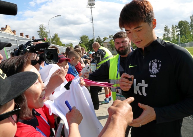 In this file photo taken June 13, 2018, South Korea national football team captain Ki Sung-yueng signs autographs for fans after training at Spartak Stadium in Lomonosov, a suburb of Saint Petersburg, Russia. (Yonhap)