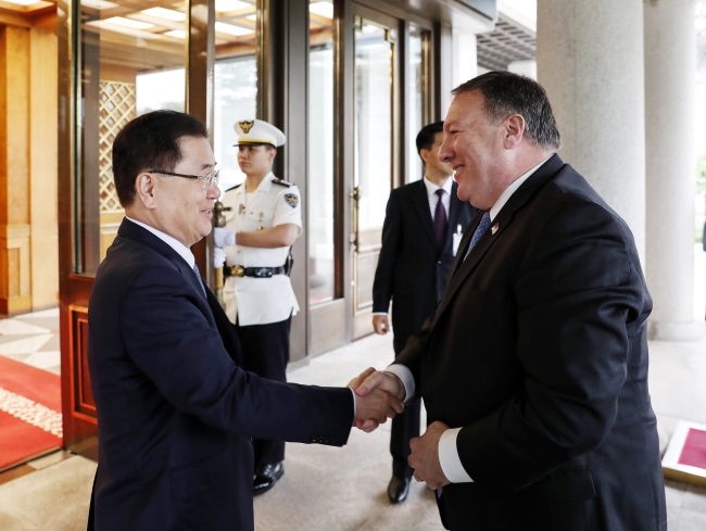 South Korea's National Security Council chief Chung Eui-yong, left, shakes hands with US Secretary of State Mike Pompeo at the Blue House in Seoul on Thursday. (Yonhap)