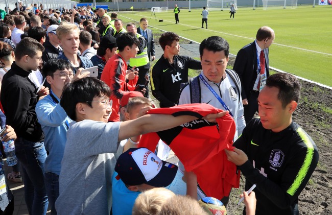 South Korea's Moon Seon-min (right) sign his autograph for fans after training at Spartak Stadium in Lomonosov, a suburb of Saint Petersburg, on June 13, 2018. (Yonhap)