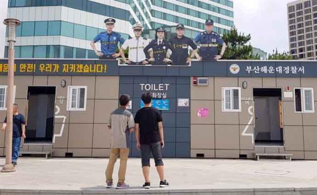 14일 부산 해운대해수욕장 이벤트 광장에 있는 이동식화장실에 해운대경찰서가 여름철 급증하는 불법 촬영 범죄를 예방하고자 조형물을 설치했다. ‘해운대 어벤져스 경찰관’으로 명명된 이 조형물은 해운대경찰서 소속으로 해운대와 송정해수욕장에 각각 근무 중인 현직 경찰관 5명이 바닷가를 지키는 형상을 하고 있다.  [연합뉴스]