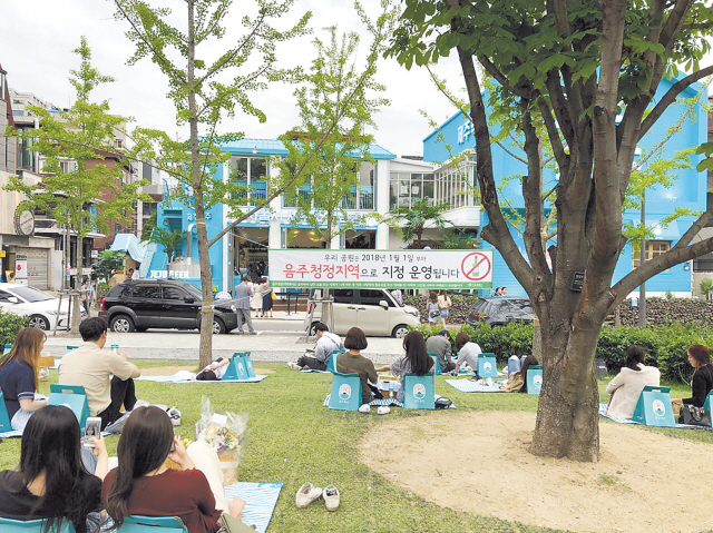 인근 관공서에서 문구를 부착한 경의선숲길에서 시민들이 제주맥주가 제공한 돗자리를 펴고 맥주를 마시고 있다.