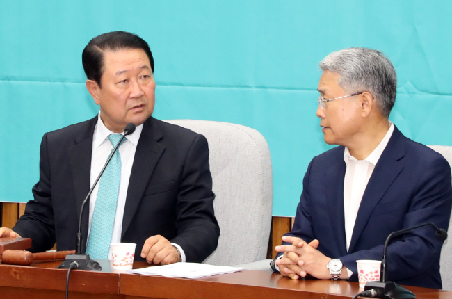 This photo taken on June 15, 2018, shows Park Joo-sun (left), a co-leader of minor opposition Bareunmirae Party, speaking to Kim Dong-cheol, the party's floor leader, at an event to disband the election camp for the June 13 local elections. (Yonhap)