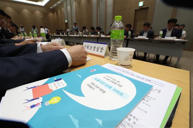 노동시간 단축 시행이 2주 앞으로 다가왔지만 근로시간을 판단할 기준이 불명확한 경우가 많아 새로운 노사갈등 요인으로 작용할 것으로 우려되는 등 혼란이 가시지 않고 있다. 사진은 지난 11일 세종컨벤션센터에서 열린 노동시간 단축 및 최저임금 현장 안착을 위한 고용노동부 긴급 주요기관장회의에서 회의 참석자가 ‘노동시간 단축 가이드’를 펼쳐 보는 모습.  [연합뉴스]