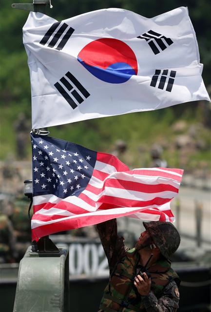 한미 군 당국이 19일 올해 8월 예정된 을지프리덤가디언(UFG) 연습을 한반도 비핵화와 평화체제 구축을 목표로 한 북미대화의 원활한 추진을 위해 일시 중단하기로 결정했다. 사진은 2013년 경기도 파주 휴전선 인근에서 열린 한미연합훈련 중 한 병사가 태극기와 미 성조기를 걸고 있는 모습.  [연합뉴스]