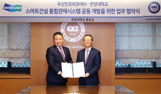손동연 두산인프라코어 사장(왼쪽)과 이영무 한양대학교 총장이 스마트건설 통합관제시스템 개발을 위한 양해각서를 체결하고 기념촬영을 하고 있다.
[제공=두산인프라코어]