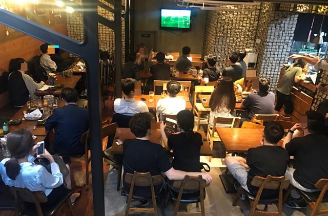 월드컵 경기와 치맥을 즐기기 위해 치킨집을 찾은 사람들. 오후 9시가 넘었는데도 밀린 주문들 때문에 테이블이 휑하다.