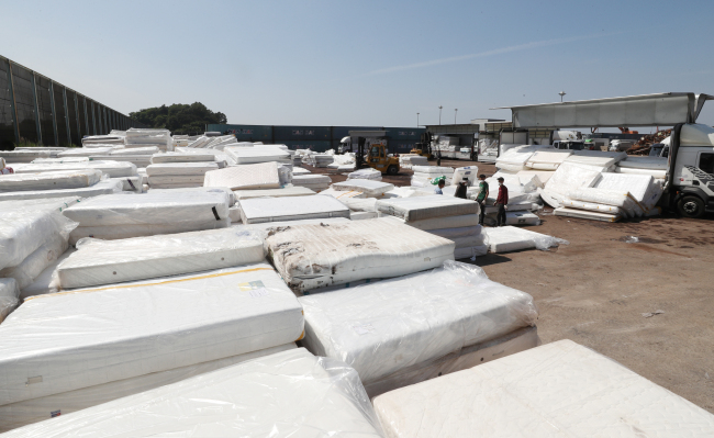 Mattresses produced by Daijin Bed Co. are piled up at an open storage yard in Dangjin port, South Chungcheong Province, Saturday. (Yonhap)