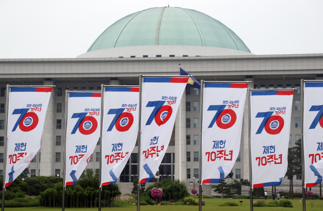 This photo taken on Sunday shows flags to mark the 70th anniversary of Constitution Day, flapping in front of the main building of the National Assembly, one month before the anniversary. (Yonhap)