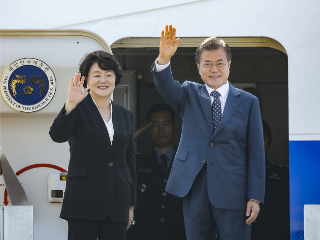 President Moon Jae-in and First Lady Kim Jung-sook wave before departing for Russia on Thursday. Yonhap