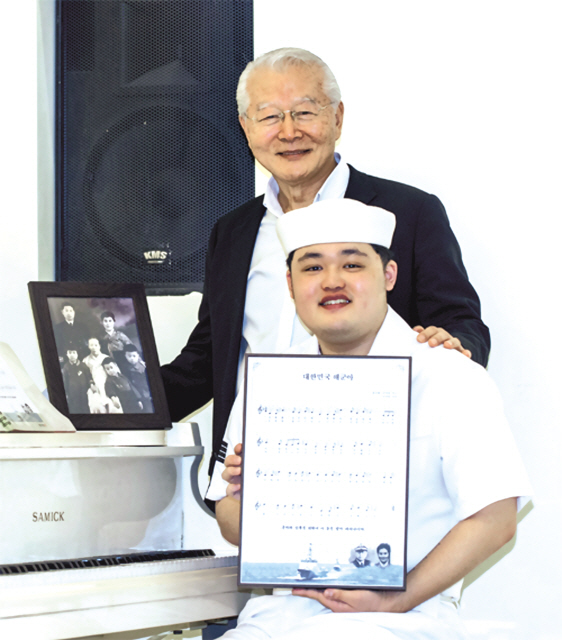 초대 해군 참모총장인 고 손원일 제독의 장남인 손명원 (뒤쪽) 손컨설팅컴퍼니 대표가 자신이 만든 군가인 ‘대한민국 해군아’의 악보를 든 해군 수병과 기념촬영을 하고 있다.