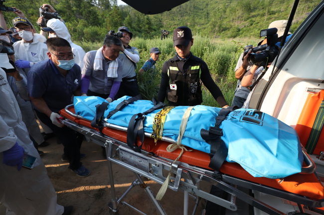 Police carry out the body found on Gangjinsan mountain, South Jeolla Province, on Sunday (Yonhap)