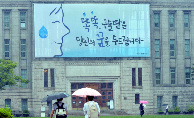 서울도서관의 그림판이 바뀌었다. 여름을 맞아 시원한 파란색을 바탕으로 땀을 많이 흘리는 계절에 열심히 일하는 시민의 모습을 글귀에 담았다. <br />정희조 기자/checho@heraldcorp.com  180626