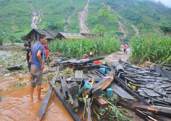 In this picture taken on June 25, 2018 shows a Vietnamese man looking at the debris of his house destroyed by flash floods in northern Ha Giang province. Flash floods and landslides killed 15 people in Vietnam's mountainous north, officials said on June 26, 2018, after storms ravaged homes and wiped out crops and infrastructure. (AFP-Yonhap)